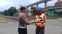 Petugas dari Satuan Lalu lintas Polres Cimahi memberikan batuan rompi, topi dan paket sembako buat para petugas relawan penjaga lintasan kereta api yang berada di Kampung Sumur Bor, Desa Cilame, Kec. Ngamprah. Foto/BANDUNGSATU.COM